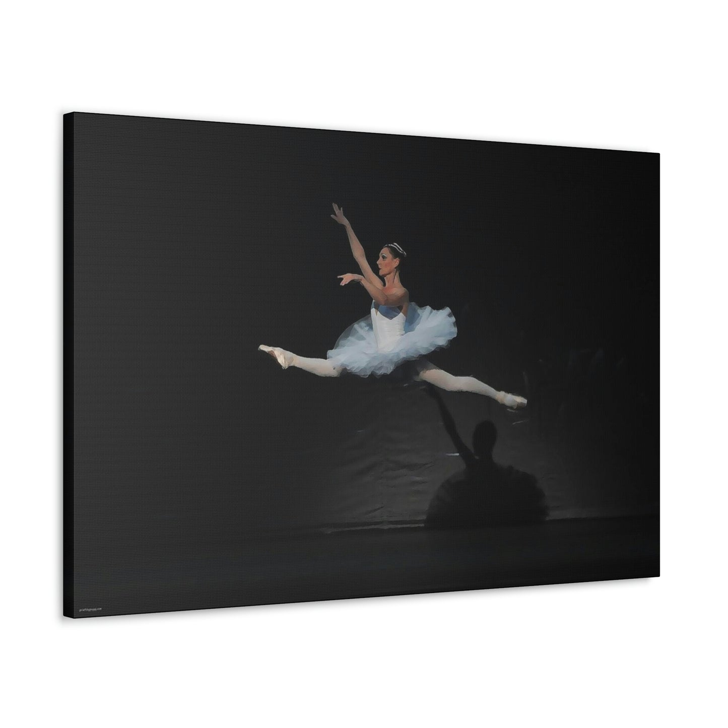 Canvas print hanging on white wall of Ballerina in a white tutu in mid-air performing a leap. Background is black