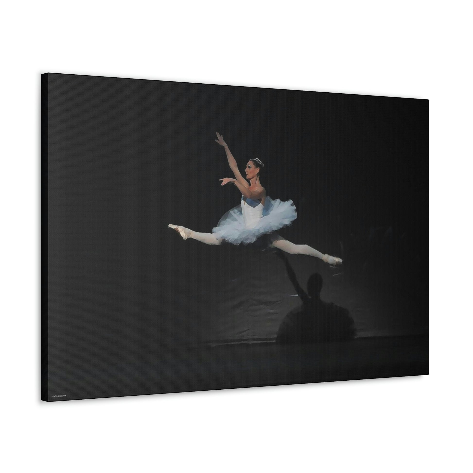 Canvas print hanging on white wall of Ballerina in a white tutu in mid-air performing a leap. Background is black