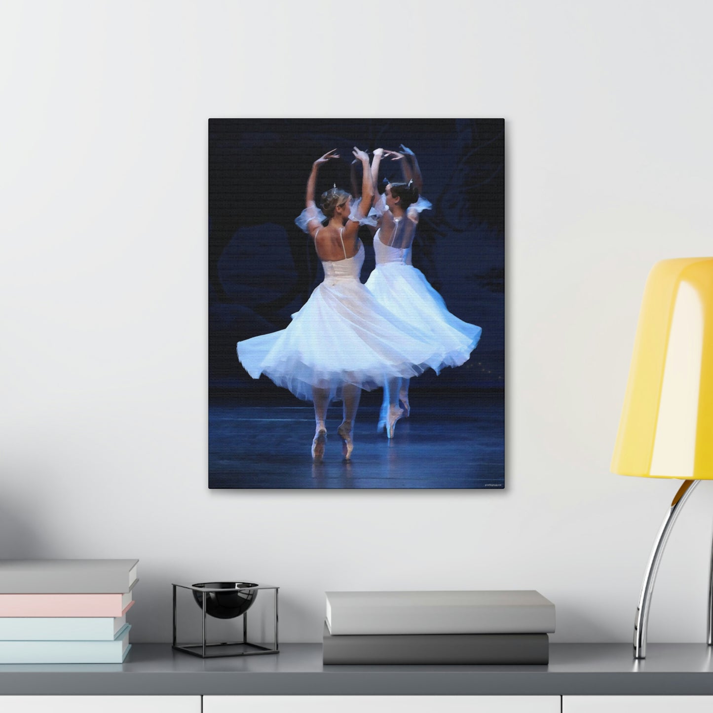 painting of two ballerinas wearing tiaras and white dresses on point hanging over a desk