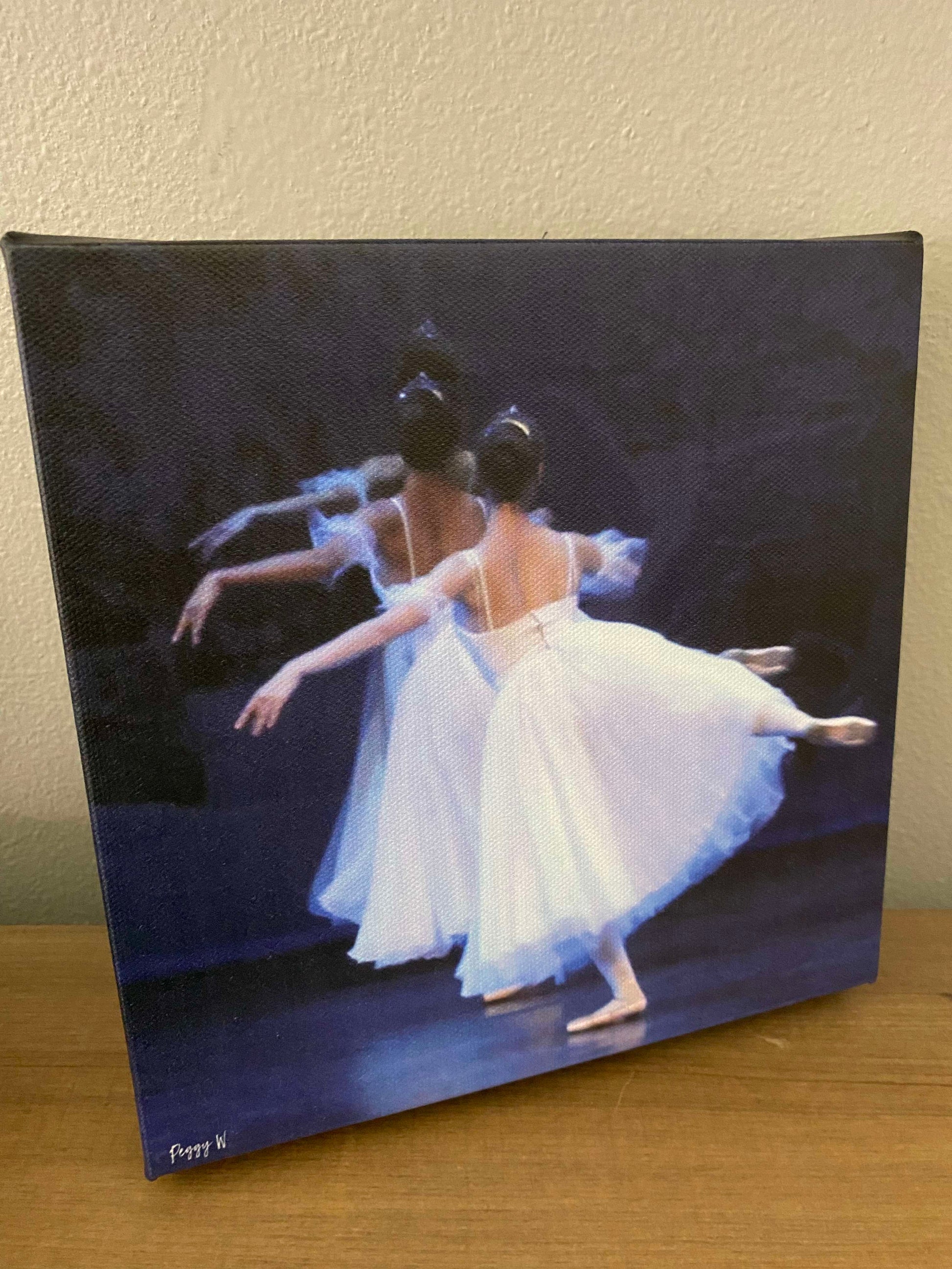 An oil painting of three ballet dancers from the rear dancing on stage in flowing white dresses printed on canvas