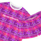 close up view of short pink and purple ballerina print pajamas, white ribbed neck with white writing