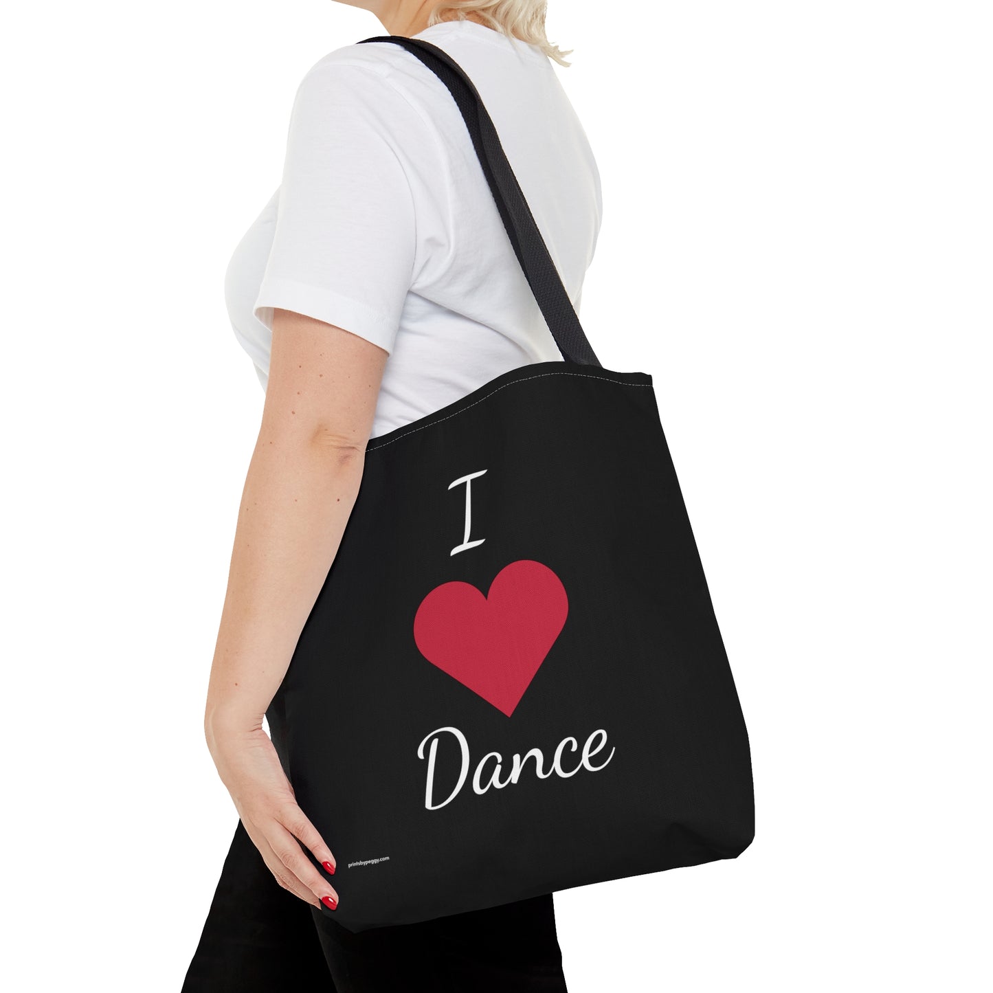 Dance tote bag being carried on a woman's shoulderd. Black background and white letters. I heart dance