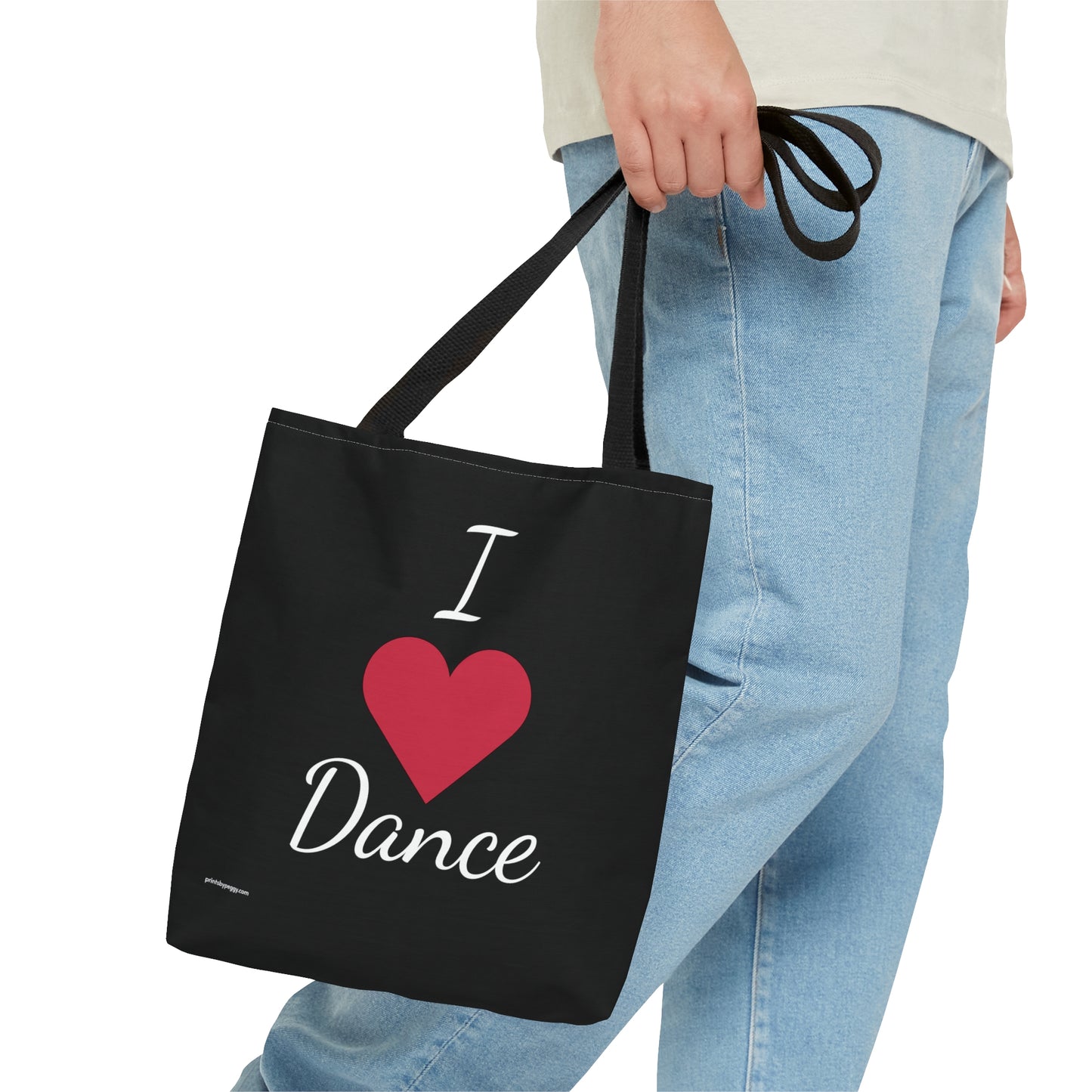 Black dance bag being carried in hand. Front side says I heart dance with a red heart instead of the word.