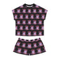 Shortie pajamas laid flat with black ribbed neck. Print is ballerinas in blue on a black background.