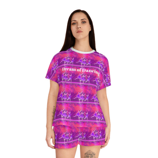 front view of model wearing shortie pajama set with Dream of Dancing written in white letters on a pink and purple ballerina print