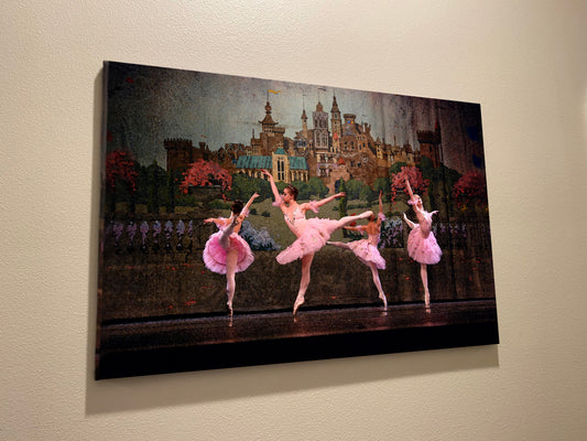 A painting hanging on a wall of Four ballerinas dancing in a circle on stage with a castle backdrop dressed in pink