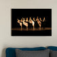 A kick line comprised of male and female dancers. Females are in white and the males are in tuxedos with top hats