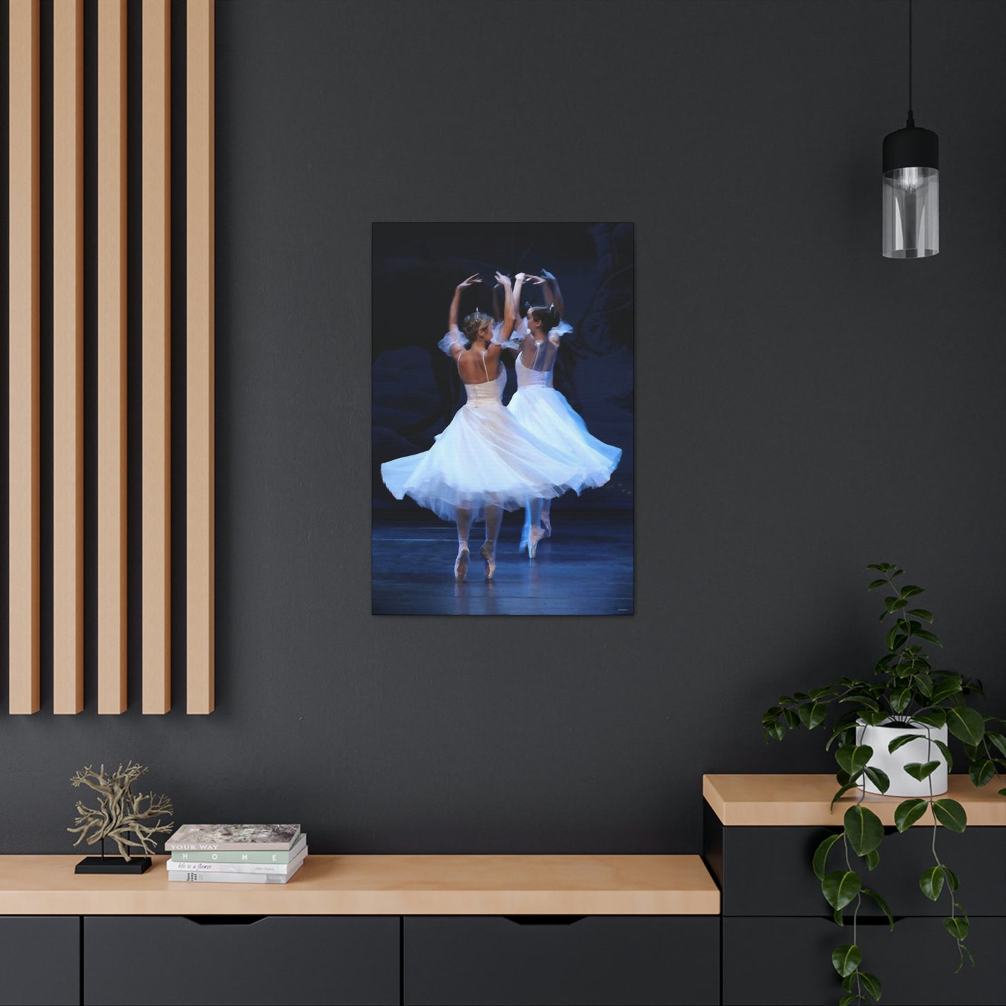 painting hanging on a dark wall in a home setting of two ballerinas wearing tiaras in white dresses on point  