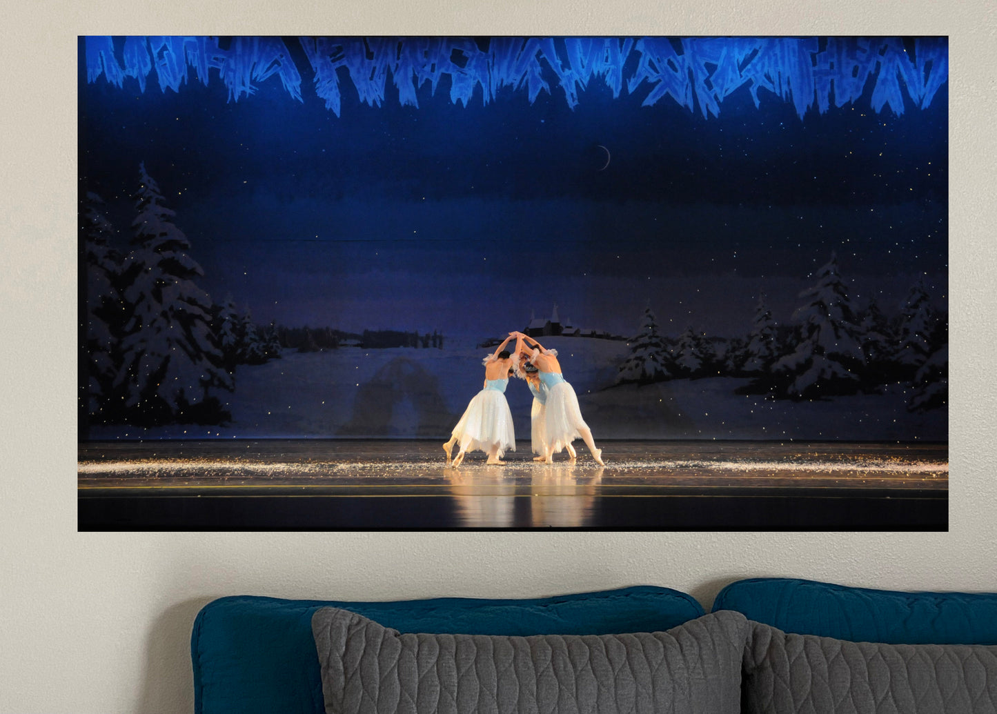 a photo of a painting hanging in a home setting of Ballet dancers performing on stage in blue and white with a blue winter scene backdrop and snowflakes falling around them