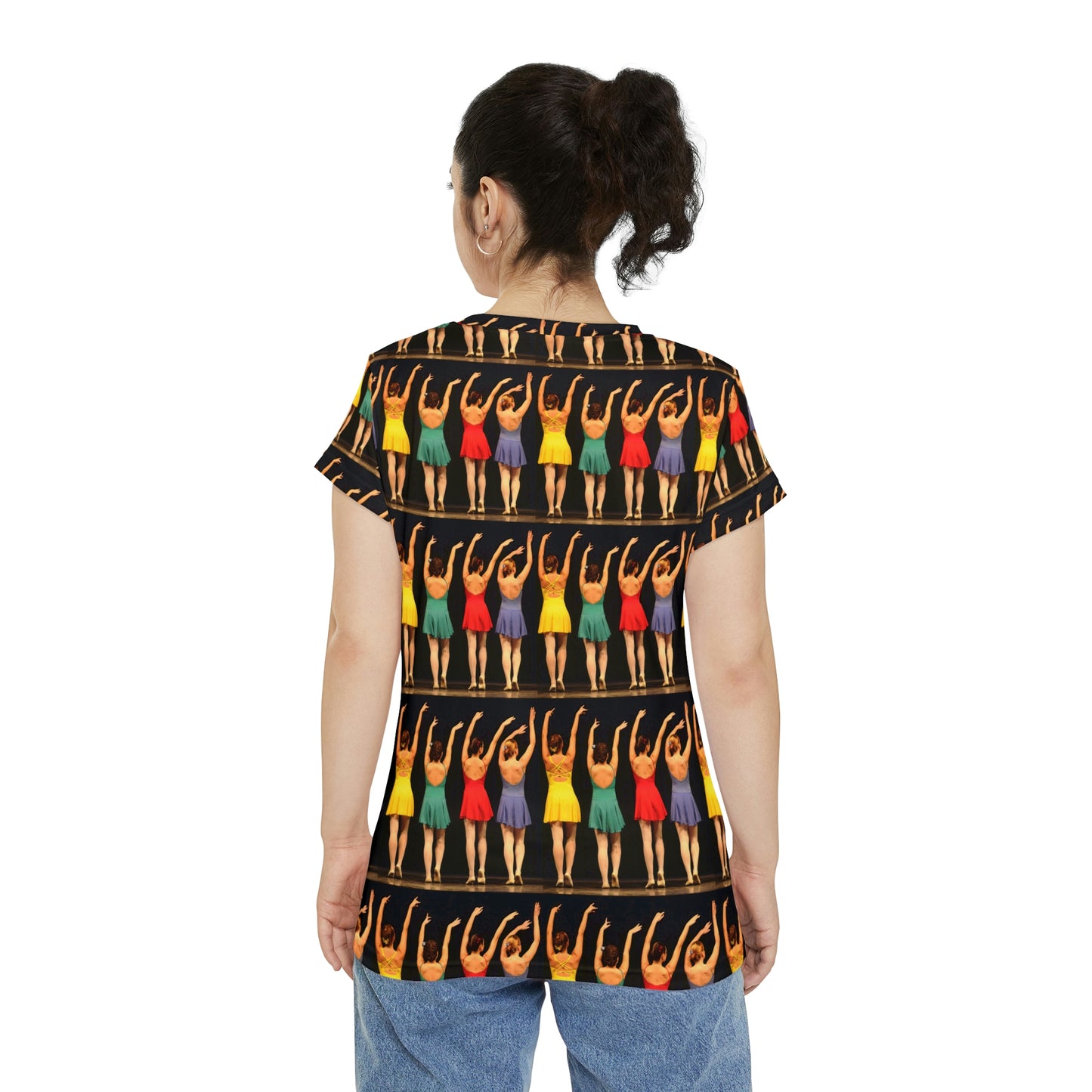 back view of a model wearing a short sleeve shirt with dancers lined up wearing bright colored costumes from the rear with their hands in the air printed on it