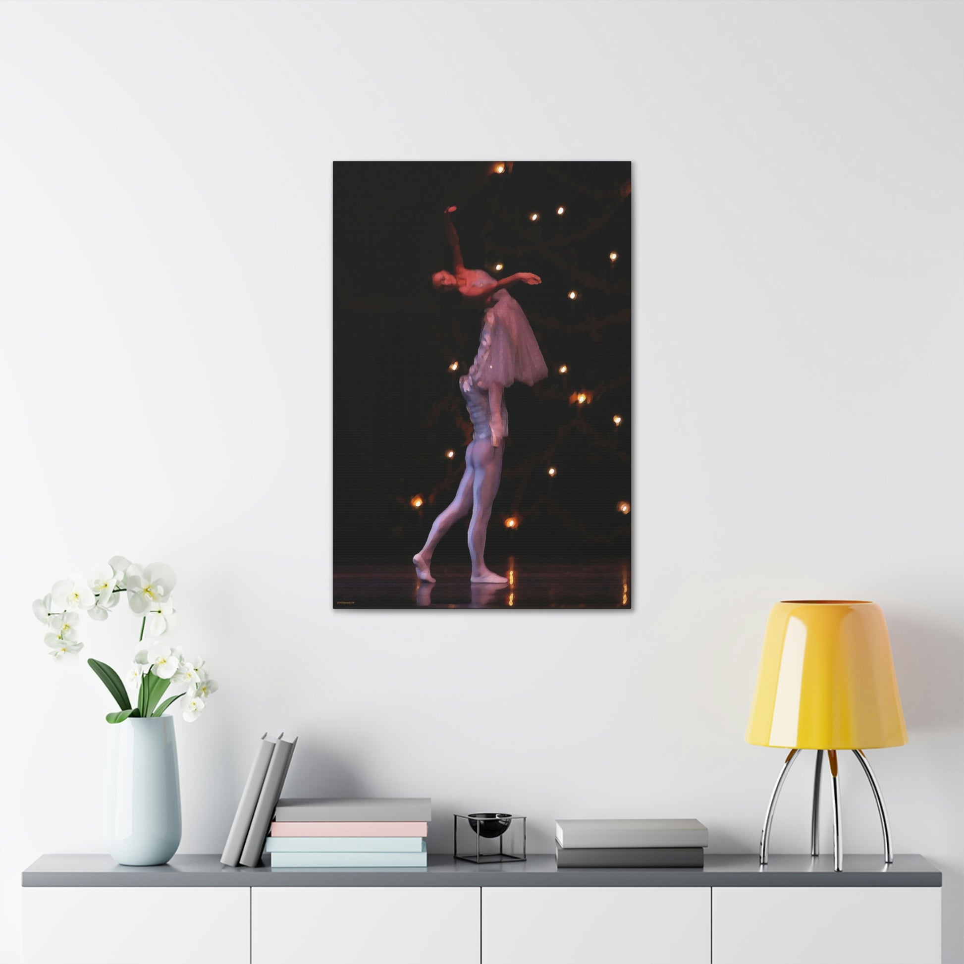 Canvas print hanging on a white wall over a desk of a ballet couple with the male dancer lifting the female dancer as they are exiting the stage.