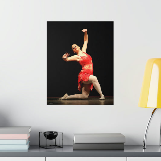 Poster hanging on a wall over a desk of a dancer performing on stage wearing a red costume on a premium matte poster