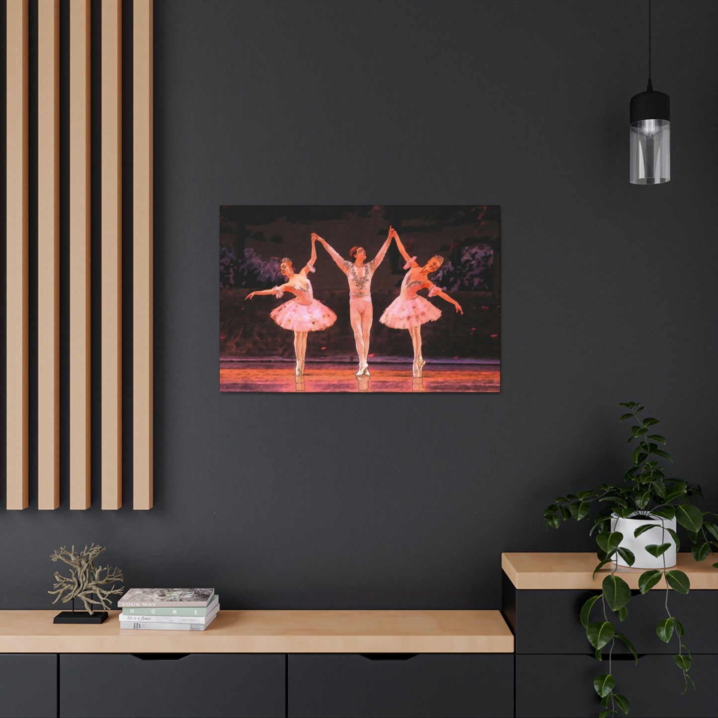 Canvas print of a sketch style painting hanging on a dark wall of 3 dancers performing on stage holding hands. Dancers in pink.