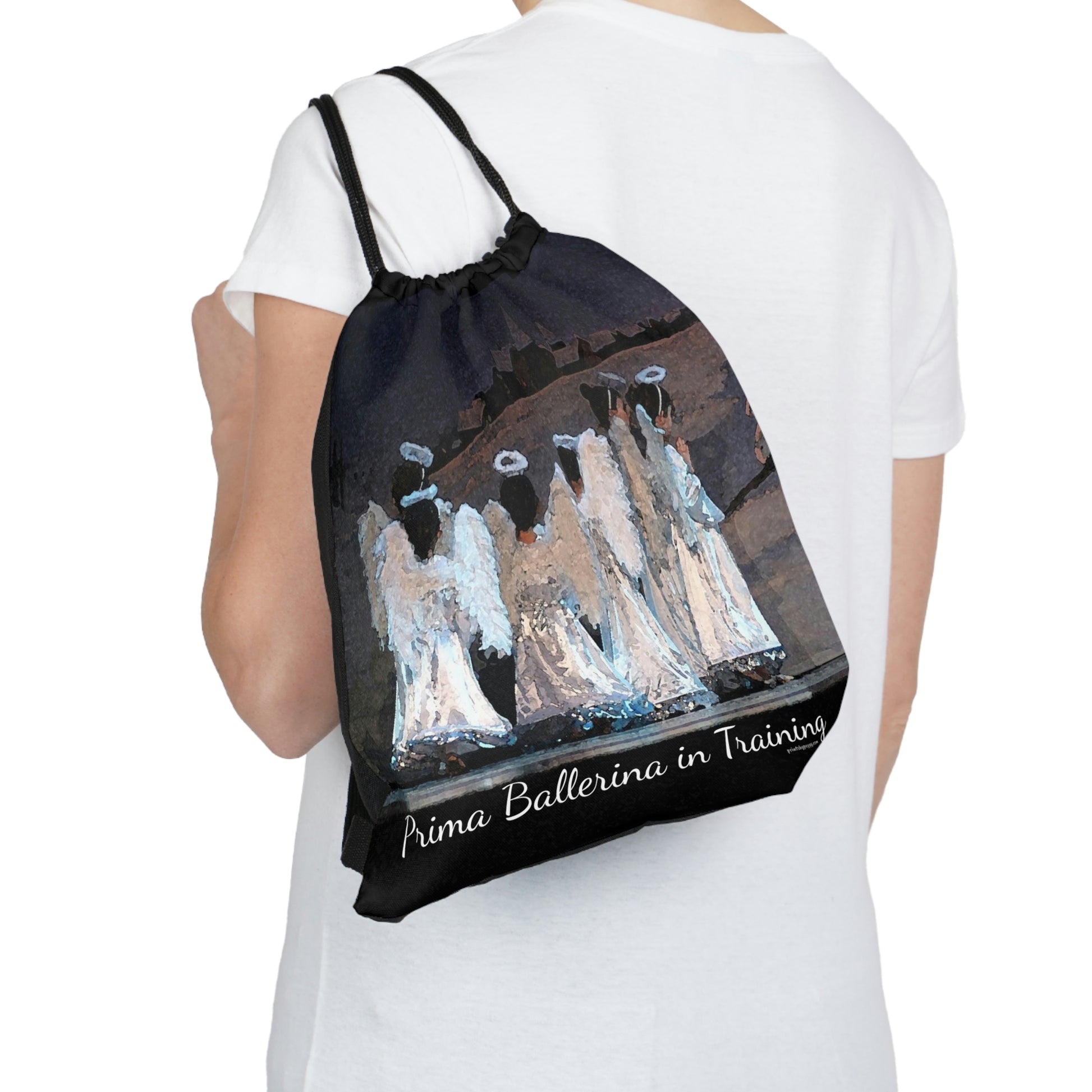 black drawstring bag with the text Prima Ballerina in Training written at the bottom with several youth dancers dressed in white as angels in the Nutcracker.