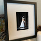 photo of a framed print of graceful ballet dancer from the back dressed in white performing on stage