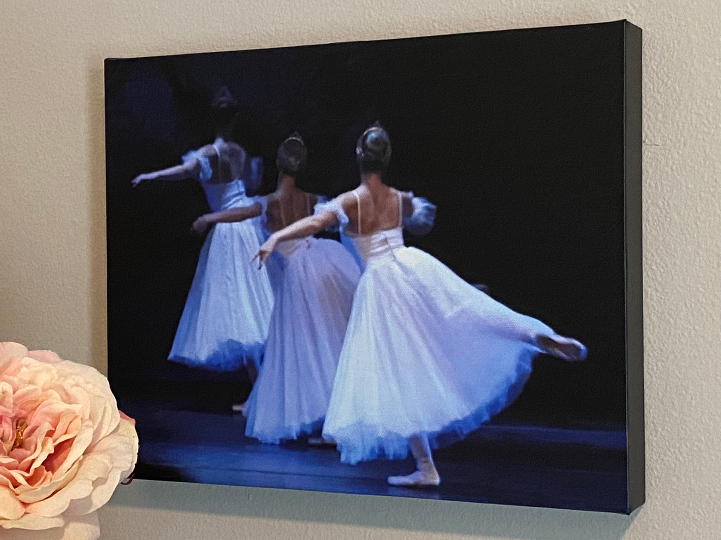 a painting of Three ballerinas performing a graceful dance on a dark backdrop