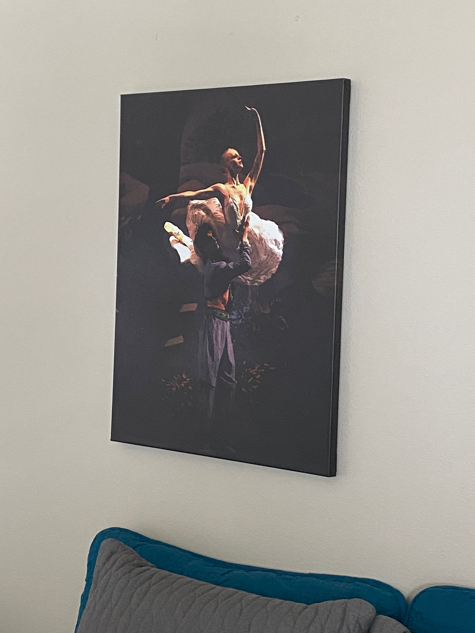 A photo of a dance art painting on the wall of a bedroom of a ballet dance couple performing on a stage with a dark backdrop with dramatic lighting..