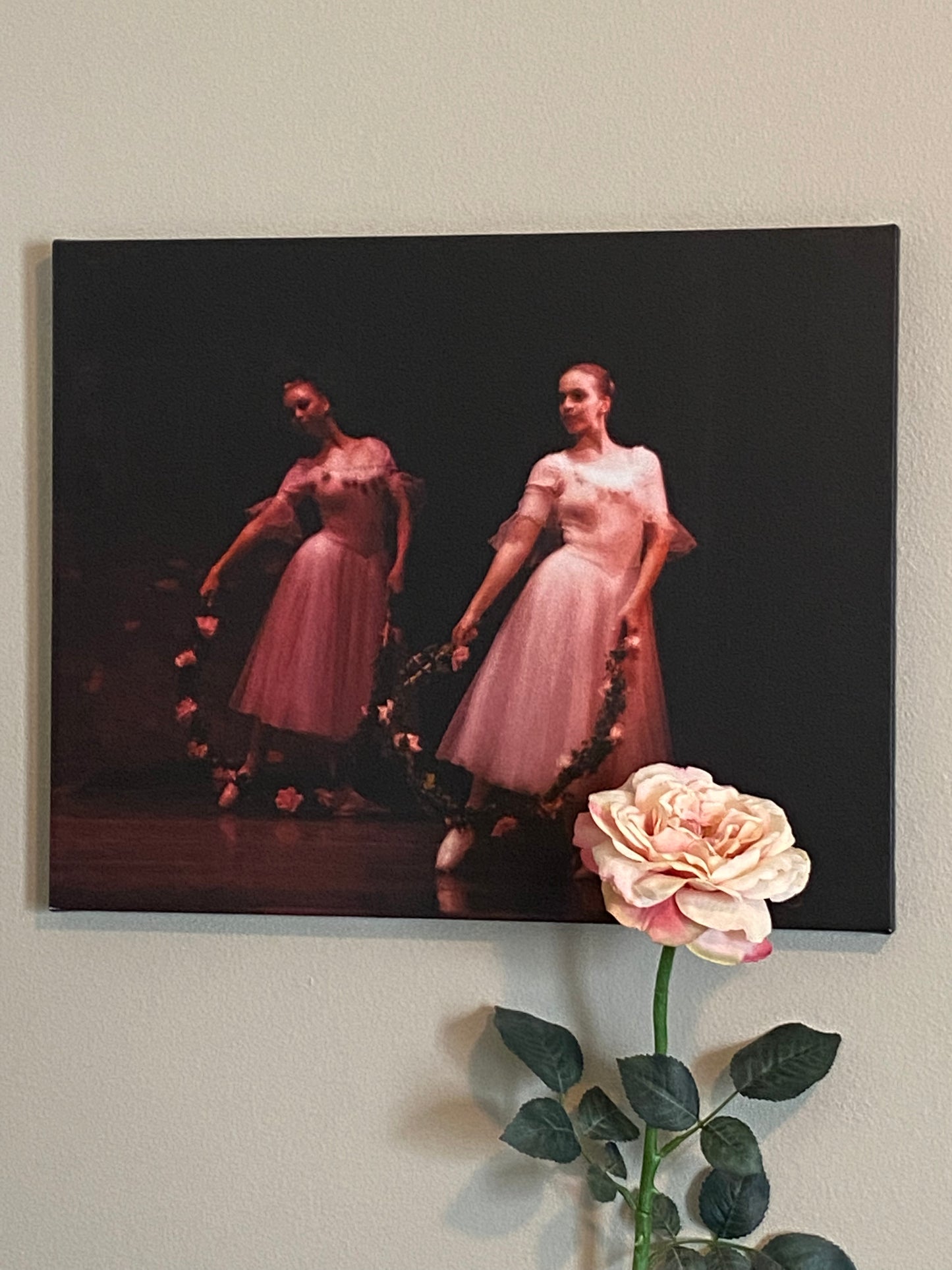 painting hanging on a wall of ballerinas in pink with pink rose wreaths