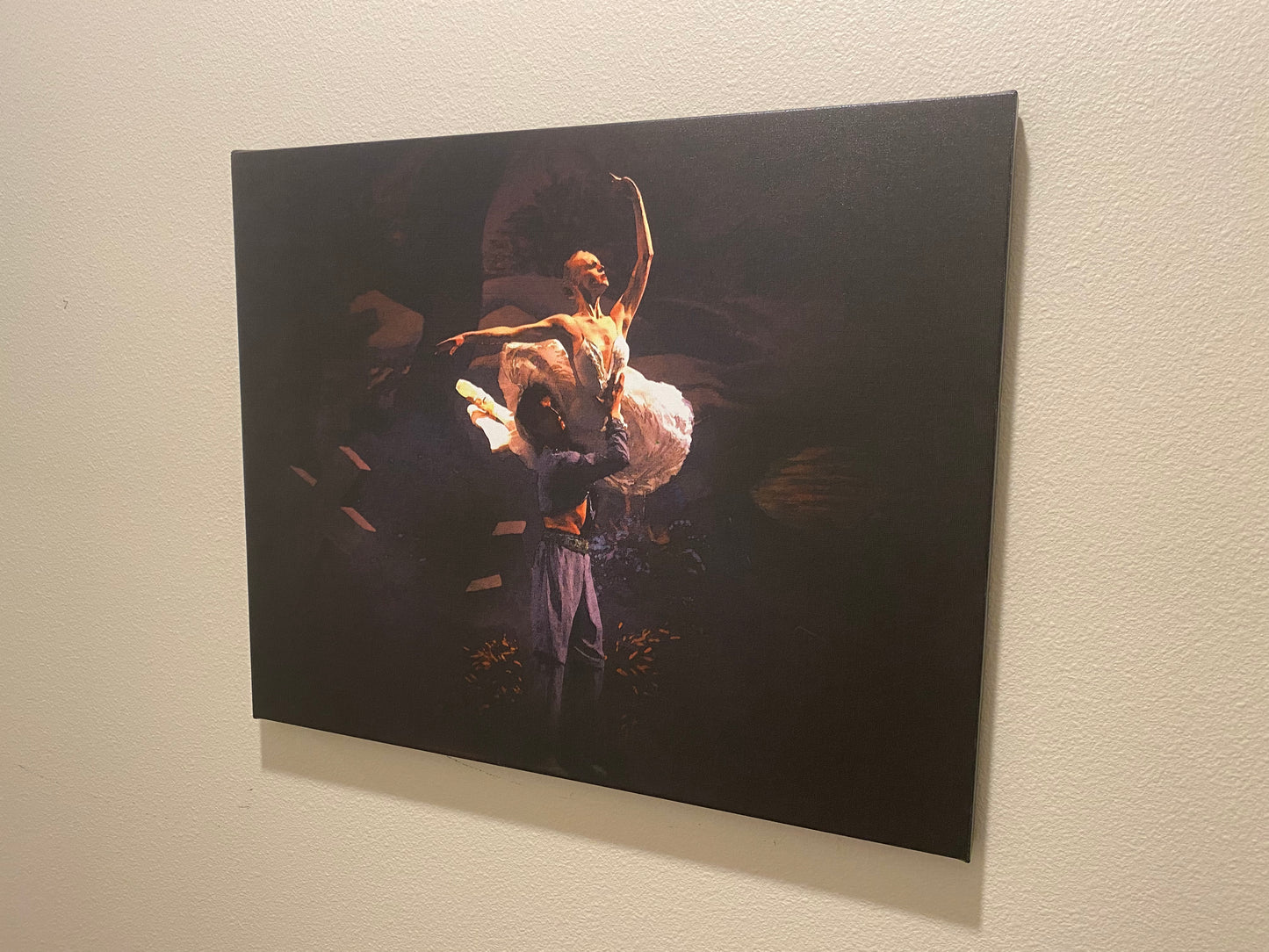 a ballet dance art painting on a wall of a couple performing on stage on a dark backdrop of him lifting her in a dramatic pose