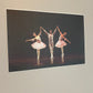 Ballet dancers performing on dark stage
