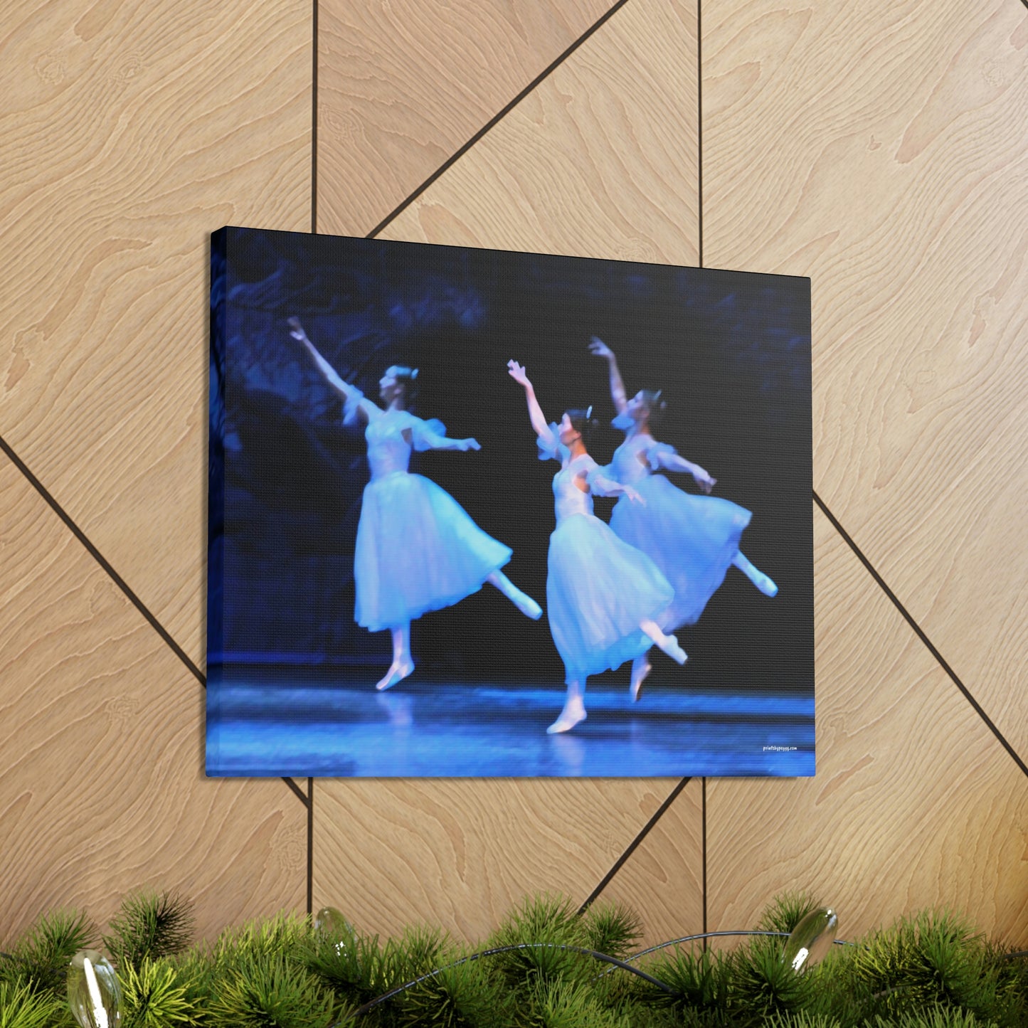 a photo of a painting in a home setting of three ballerinas performing on a stage dressed in white casting hues of blue 