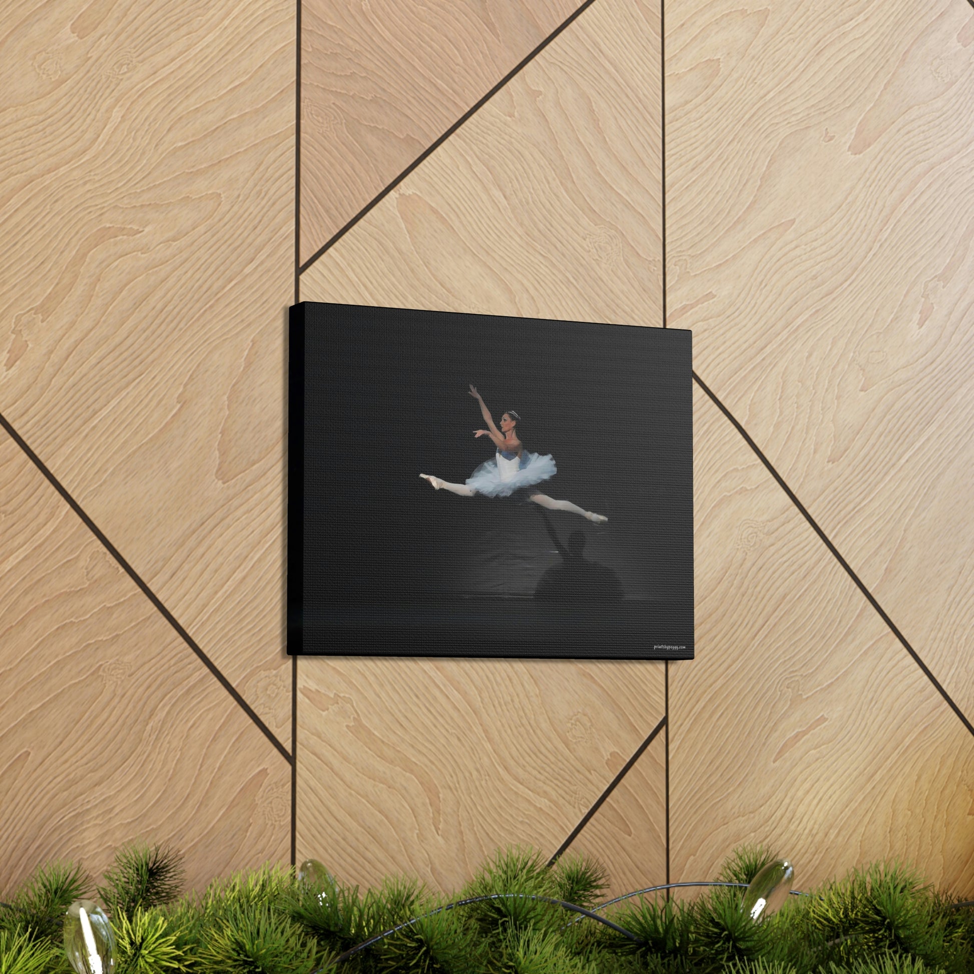 Canvas print of Ballerina in a white tutu in mid-air performing a leap. Background is black  