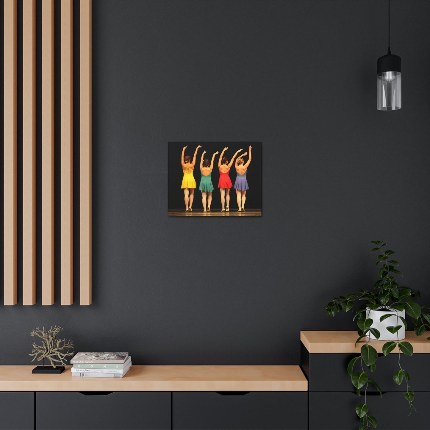 Art image hanging on the wall in a home setting of a painting of four modern dancers from the rear on stage in bright costumes