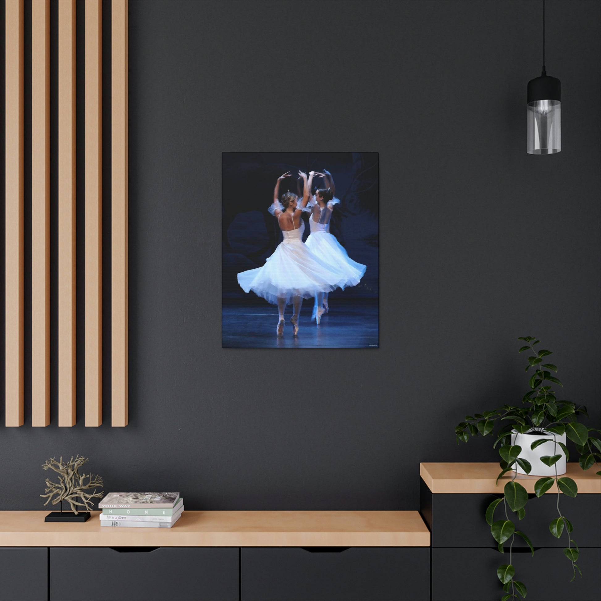 painting of two ballerinas wearing tiaras and white dresses on point hanging on a dark wall in a home setting