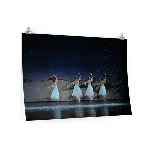 four ballet dancers dressed in blue  with snow falling in a winter scene.